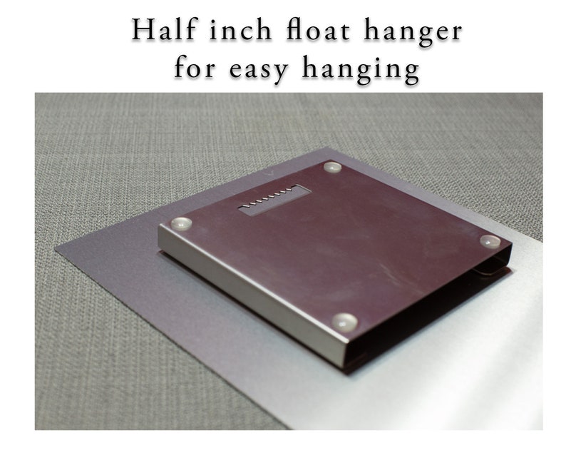 May include: A close-up of the back of a metal print showing a half-inch float hanger for easy hanging.