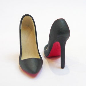 May include: A pair of black high-heeled shoes with red soles. The shoes are made of a smooth material and have a pointed toe.
