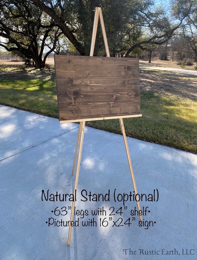 May include: A wooden easel with a dark brown sign. The easel has natural wood legs and a 24-inch shelf. The sign is 16x24 inches. The text on the image says "Natural Stand (optional)" and "63" legs".