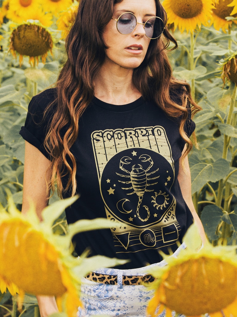 May include: A black t-shirt with a gold graphic of a scorpion and the text "Scorpio" and "Nov 23 - Nov 21".