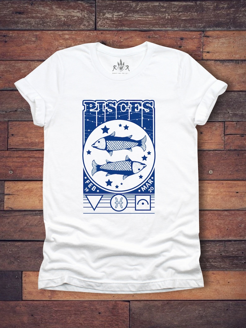 May include: White t-shirt with a blue graphic of the Pisces zodiac sign. The graphic includes two fish, stars, and the text "Pisces" with the dates "Feb 19" and "Mar 20".