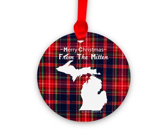 May include: Round Christmas ornament with a red and black plaid pattern. The ornament features a white outline of the state of Michigan and the text "Merry Christmas From The Mitten".