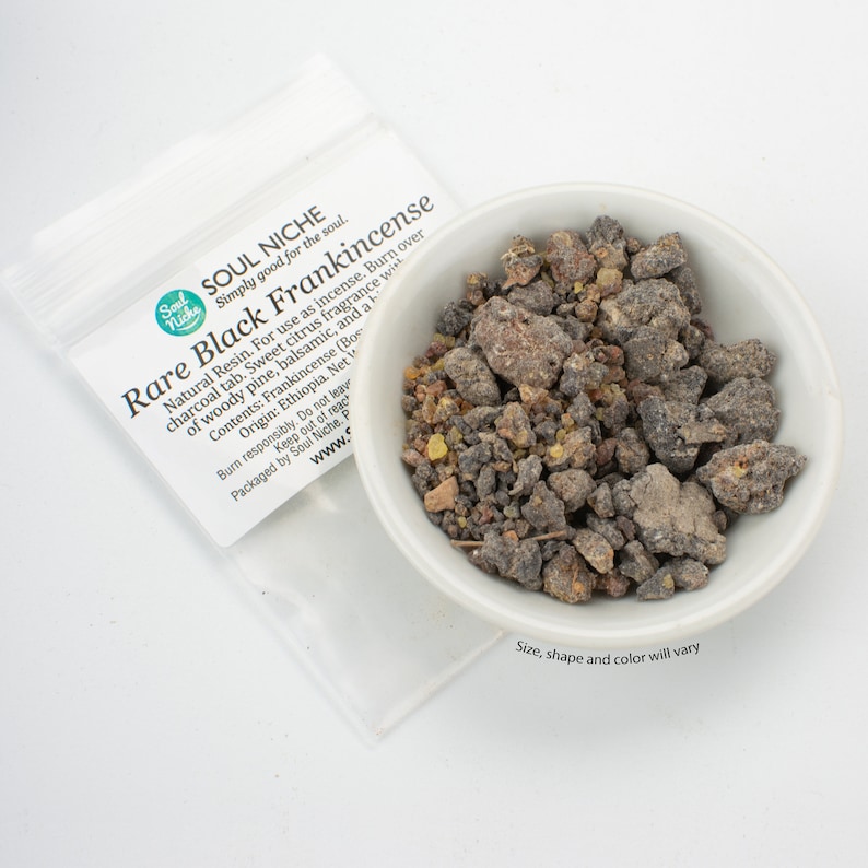 May include: A small white bowl filled with dark gray and amber colored frankincense resin. The bowl is sitting on a white surface. The text on the packaging reads "Soul Niche Simply good for the soul. Rare Black Frankincense Natural Resin. For use as incense. Burn over charcoal tab. Sweet citrus fragrance with of woody pine, balsamic, and a Contents: Frankincense (Boswellia Sacra) Origin: Ethiopia. Net Wt. 1 oz. Burn responsibly. Do not leave unattended. Keep out of reach of children. Packaged by Soul Niche. www.soulniche.com Size, shape and color will vary."