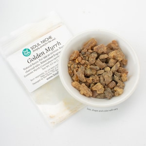 May include: A small white bowl filled with golden brown myrrh resin. The resin is in various sizes and shapes. The bowl is sitting on a white surface. The text on the label reads "Soul Niche Golden Myrrh Natural Resin. For use as incense. Burn charcoal tabs. Bittersweet fragrance. Contents: Myrrh (Commiphora myrrh) Net Wt. 0.5 oz (14g) Burn responsibly. Do not leave unattended. Keep out of reach of children. Packaged by Soul Niche. PO Box www.Soul"