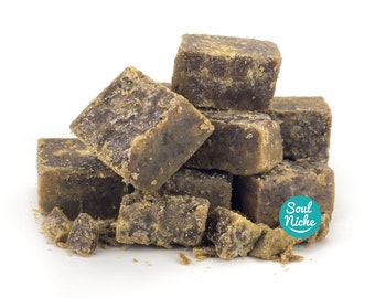 May include: A pile of brown sugar cubes, some broken into smaller pieces, on a white background. The text "Soul Niche" is visible in a green circle on the right side of the image.