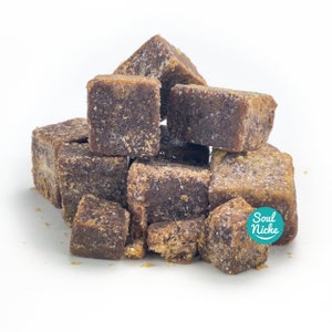 May include: A pile of brown sugar cubes, some are broken into smaller pieces. The sugar cubes are on a white surface. The text "Soul Niche" is visible in a green circle.