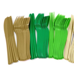 Può includere: Un set di posate di plastica in verde, oro e bianco. Le posate includono forchette, coltelli e cucchiai.