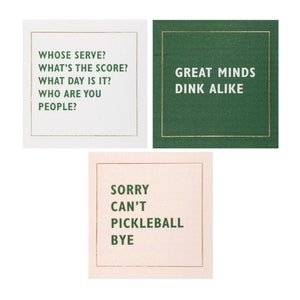 May include: Three square cards with gold trim and white text on a white, green, and pink background. The text on the cards reads: "Whose serve? What's the score? What day is it? Who are you people?", "Great minds dink alike", and "Sorry can't pickleball bye".