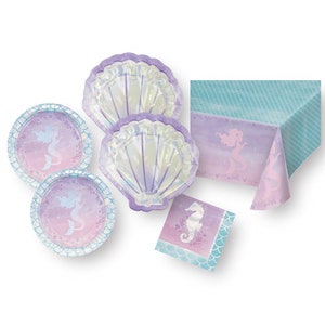 May include: A mermaid-themed party supplies set with a blue and purple tablecloth, two iridescent purple seashell plates, two purple plates with a mermaid silhouette, and a purple napkin with a seahorse.