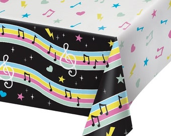May include: Black and white plastic tablecloth with a musical note design. The tablecloth has a black background with colorful stripes and musical notes. The other side of the tablecloth is white with a scattered design of musical notes, stars, and lightning bolts.