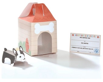 May include: A dog-themed gift set featuring a dog house-shaped box with a bone and fire hydrant design, a small black and white dog figurine, and an adoption certificate with paw prints. The box has a red roof and a handle.