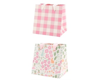 May include: Two gift bags, one with a pink and white gingham pattern and the other with a floral and bunny pattern.