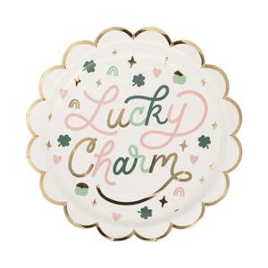 May include: White paper party plate with a gold scalloped edge. The plate has a green, pink, and gold design with the text "Lucky Charm".