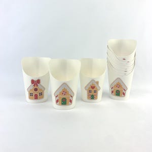Puede incluir: Conjunto de vasos de papel blancos con dise&ntilde;os de casas de jengibre. Los vasos son perfectos para servir aperitivos o golosinas en una fiesta navide&ntilde;a.