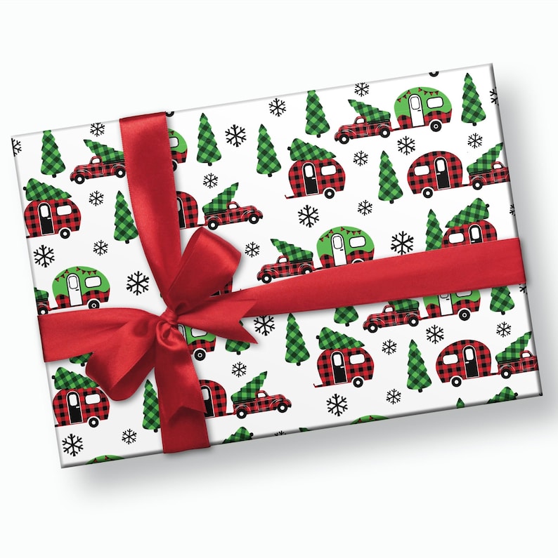 Op de afbeelding: Rood en groen geruit kerstpapier met een patroon van campers met kerstboom op het dak, rode vrachtwagens met kerstboom in de laadbak en sneeuwvlokken.