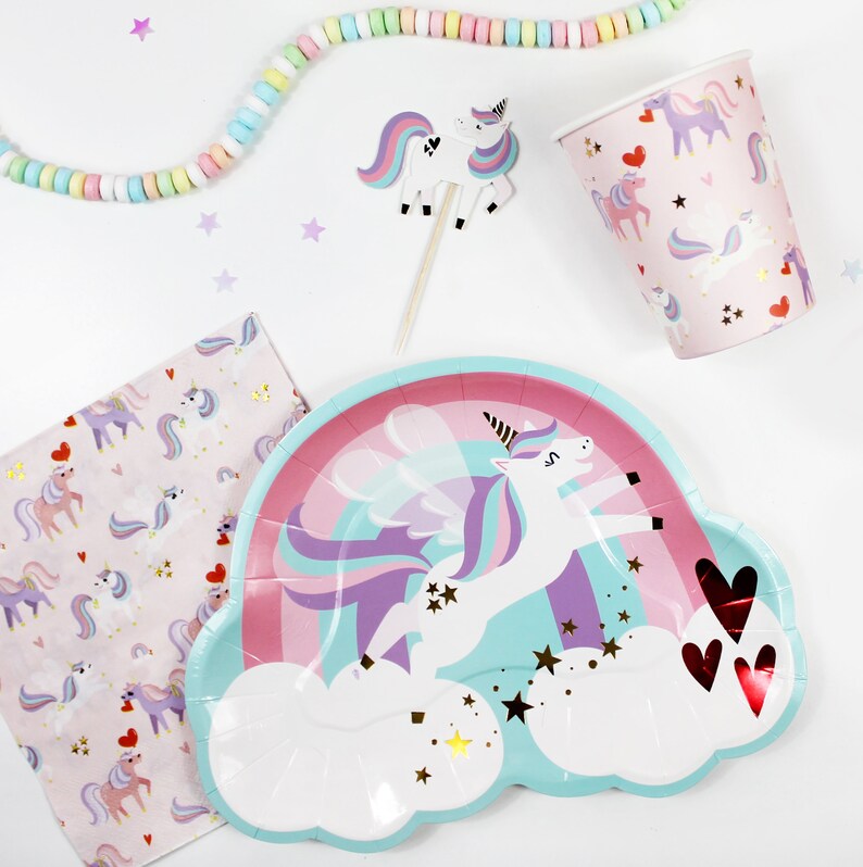 May include: A pastel blue and pink paper plate with a unicorn flying over a rainbow and clouds. The unicorn has a purple mane and tail and gold glitter stars are scattered around the plate.
