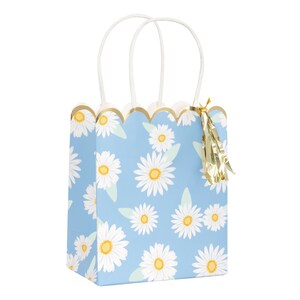 May include: A blue gift bag with a white daisy pattern and gold trim. The bag has white handles and a gold tassel.