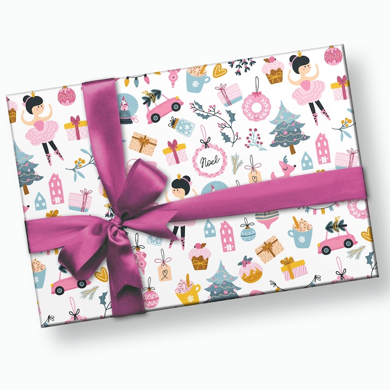 May include: Pink and white wrapping paper with a Christmas theme. The paper features a repeating pattern of ballerinas, Christmas trees, houses, ornaments, and other festive elements. The paper is tied with a pink ribbon.
