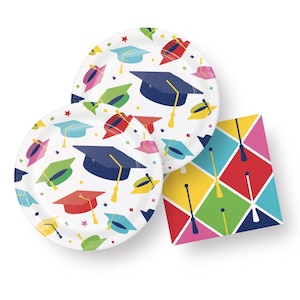 May include: A set of graduation party supplies featuring two white paper plates with a colorful pattern of graduation caps and confetti and a single napkin with a colorful diamond pattern.