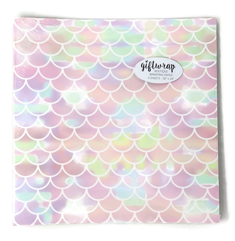 May include: A pack of iridescent mermaid scale gift wrap. The wrapping paper has a holographic finish and features a pink, white, and green color scheme. The pack contains 3 sheets of wrapping paper, each measuring 30 inches by 20 inches.