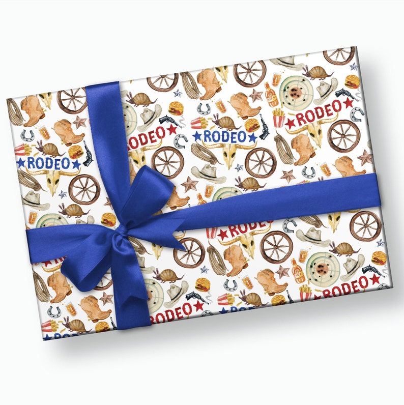 Puede incluir: Papel de regalo blanco con un patr&oacute;n repetido de ilustraciones de acuarela de botas de vaquero, herraduras, armadillos, sombreros y ruedas de carro. El texto "RODEO" se repite en todo el patr&oacute;n en rojo, blanco y azul.