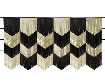 May include: Black and gold chevron fringe curtain. The curtain is made of metallic foil and has a zig-zag pattern.
