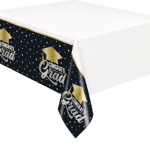 May include: Black and gold plastic tablecloth with a graduation cap and the text "Congrats Grad" repeated.