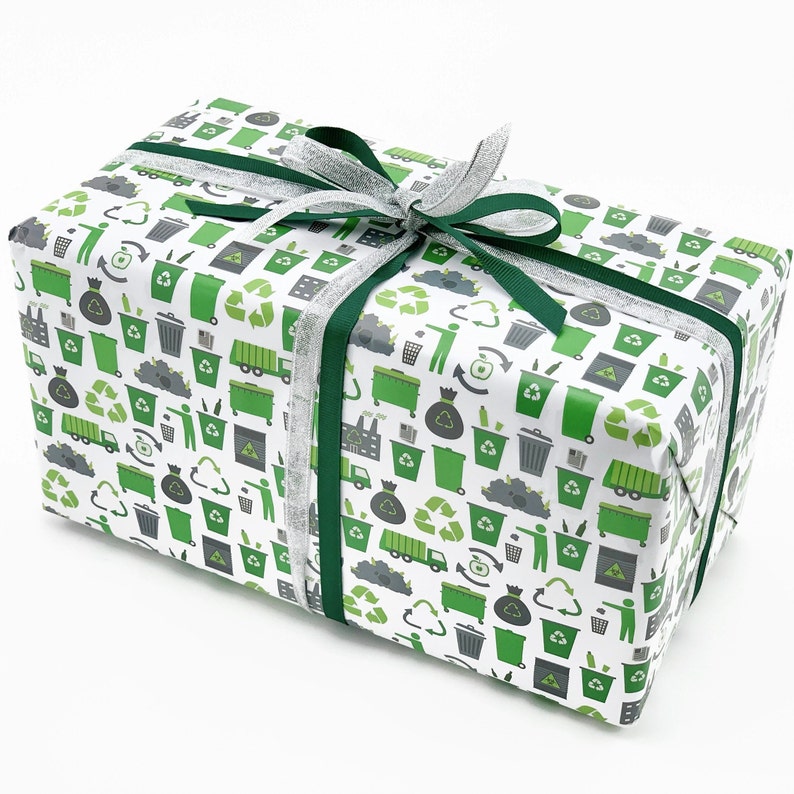 May include: A white gift box wrapped in green and grey recycling themed paper. The box is tied with a silver ribbon and a green ribbon.
