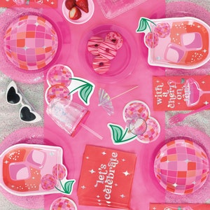 K&ouml;nnte beinhalten: Rosa und rote Partyartikel mit einem Kirsch- und Discokugel-Thema. Die Artikel umfassen Servietten, Teller und einen Strohhalm. Die Servietten haben den Text "Let's celebrate" und "with a cherry on top".