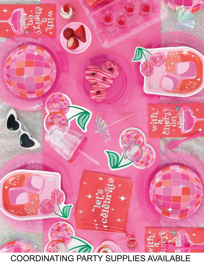 K&ouml;nnte beinhalten: Rosa und rote Partyartikel mit einem Kirsch- und Discokugel-Thema. Die Artikel umfassen Servietten, Teller und einen Strohhalm. Die Servietten haben den Text "Let's celebrate" und "with a cherry on top".