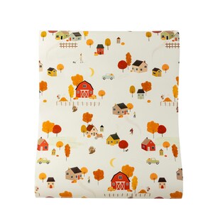 May include: A white background with a repeating pattern of red barns, yellow houses, and orange trees. The houses and barns have white trim and the trees have brown trunks. There are also small cars, pumpkins, and turkeys in the pattern.