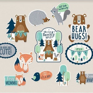 May include: A set of 10 baby shower decorations featuring woodland animals and the text "It's a Boy!" in blue and white. The decorations include a fox, a bear, a hedgehog, and a squirrel. The decorations are perfect for a woodland-themed baby shower.