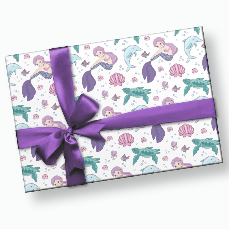 May include: Purple gift wrap with a mermaid, dolphin, turtle, and seashell pattern. The wrapping paper is tied with a purple ribbon.