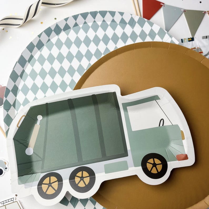 May include: A green and white paper plate with a green garbage truck design. The truck has a white cab and wheels. The plate is on top of a gold paper plate with a diamond pattern.