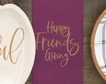 May include: A burgundy kitchen towel with the text "Happy Friends Giving" in gold lettering.