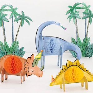 May include: A set of four paper dinosaur party decorations. The dinosaurs are blue, orange, and yellow with honeycomb centers. They are wearing party hats and are surrounded by green palm trees.