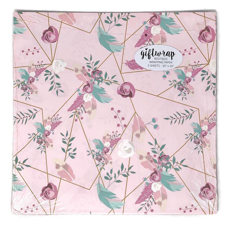 K&ouml;nnte beinhalten: Rosa Geschenkpapier mit einem Blumen- und Federmuster. Das Papier hat geometrische goldene Linien mit Akzenten in Mauve, T&uuml;rkis und Wei&szlig;. Der Text "giftwrap boutique" ist auf der Verpackung zu sehen. Jedes Blatt misst 76 cm x 51 cm.