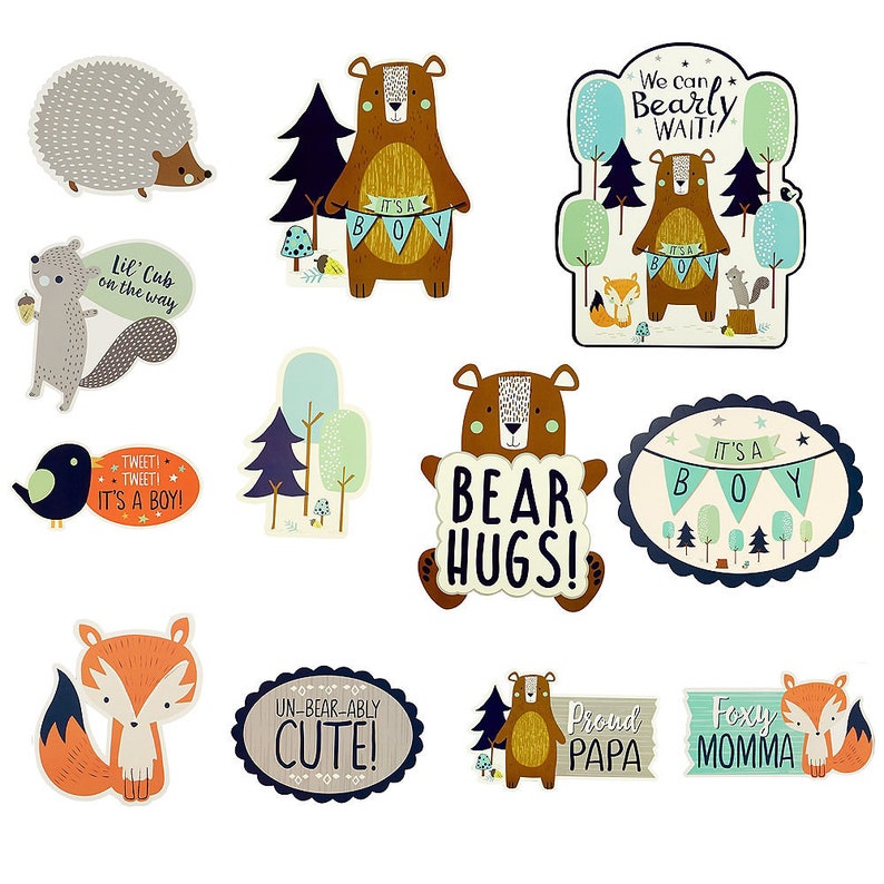 May include: A set of 10 woodland animal themed baby shower decorations. The decorations feature a variety of animals, including bears, foxes, squirrels, and birds. The decorations are printed on cardstock and have a whimsical, cartoon-like style. The text on the decorations includes phrases like "It's a Boy!" and "Bear Hugs!"