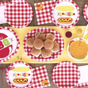 May include: Red and white checkered paper plates with different BBQ themed designs.  The plates feature images of hot dogs, corn on the cob, hamburgers, and a grill with the word "BBQ".