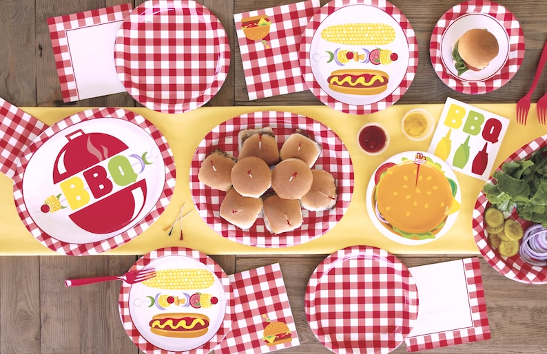 May include: Red and white checkered paper plates with different BBQ themed designs.  The plates feature images of hot dogs, corn on the cob, hamburgers, and a grill with the word "BBQ".