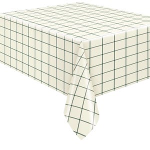 May include: A cream-colored tablecloth with a grid pattern in dark green. The tablecloth is draped over a table, with a corner hanging down. The grid pattern is evenly spaced across the surface.