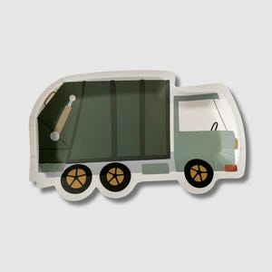 May include: Green and gray paper party plate shaped like a garbage truck. The truck has a brown handle and yellow wheels.