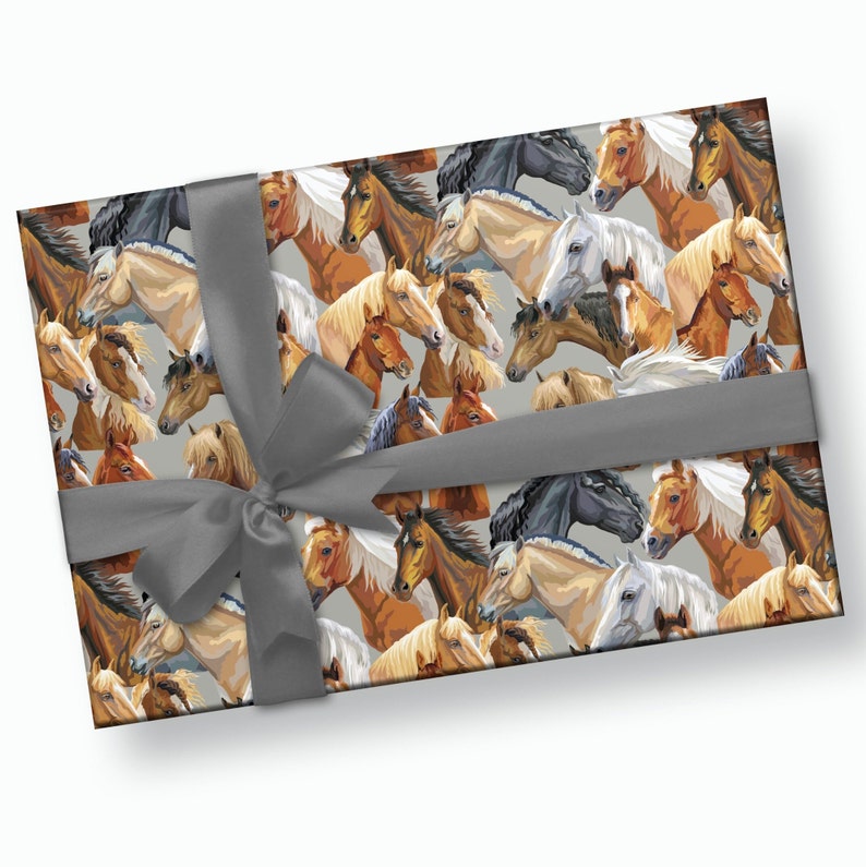 May include: A gray background with a repeating pattern of horses in various colors and poses. The horses are all facing forward and have their manes flowing. The pattern is wrapped around a gift box with a gray ribbon.