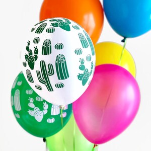 Puede incluir: Un grupo de globos coloridos con un patr&oacute;n de cactus y fresas. Los globos son verdes, blancos, naranjas, rosas, amarillos y azules.
