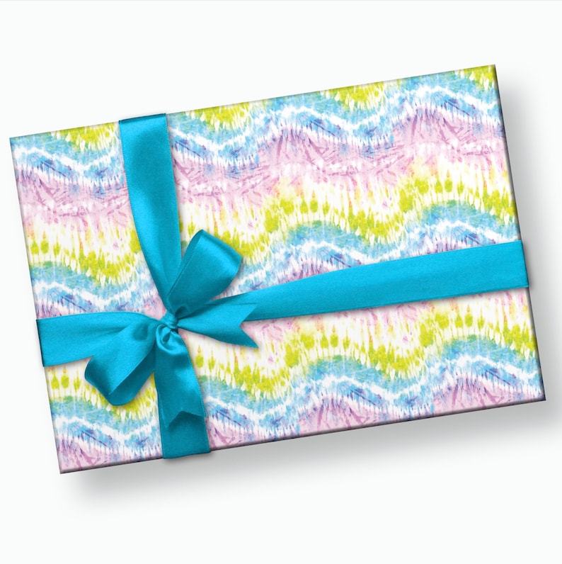 May include: A gift box wrapped in colorful tie-dye patterned paper with a bright blue ribbon tied in a bow.