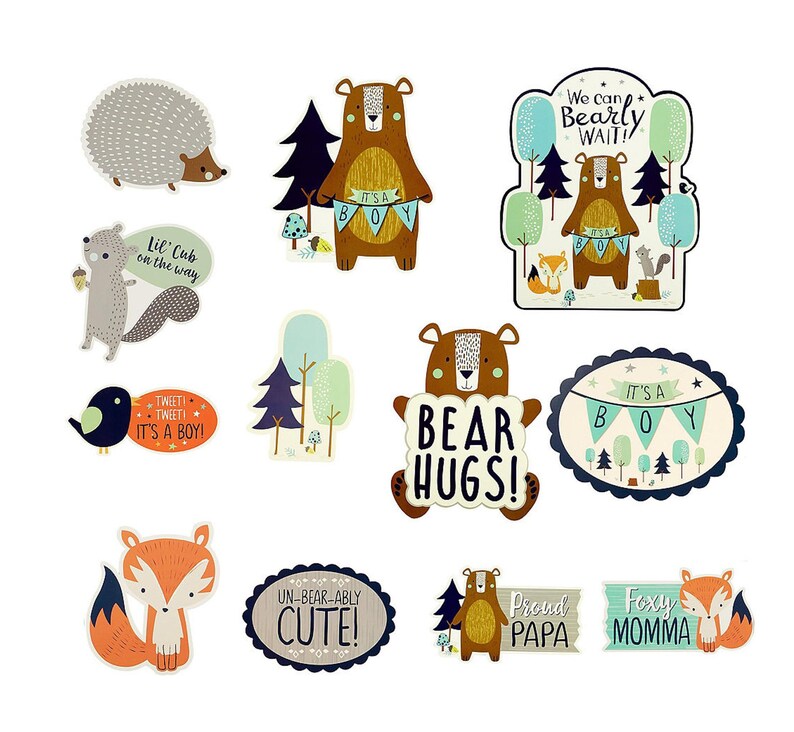 May include: A set of 10 woodland animal themed baby shower decorations. The decorations feature bears, foxes, hedgehogs, birds, and trees. The decorations are in shades of brown, green, blue, and white. The text on the decorations includes "It's a Boy", "Bear Hugs", "We can Bearly Wait", "Un-bear-ably Cute", "Proud Papa", and "Foxy Momma".