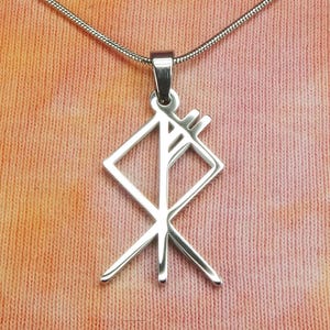 Könnte beinhalten: Halskette mit silberfarbenem Anhänger, der ein geometrisches Runensymbol zeigt. Der Anhänger hängt an einer dünnen, silbernen Kette. Der Hintergrund ist eine Mischung aus Orange- und Pfirsichtönen.