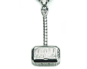 Op de afbeelding: Een zilveren ketting met een zilveren Mjolnir-hanger. De hanger is gedetailleerd met ingewikkelde gravures en een textuur.