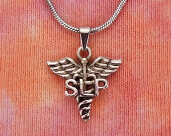 May include: Silver necklace with a pendant shaped like a medical caduceus with the letters "SLP" on it.