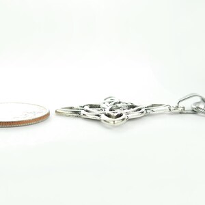 May include: Silver Celtic knot pendant necklace with a silver chain. The pendant is about the size of a US quarter.
